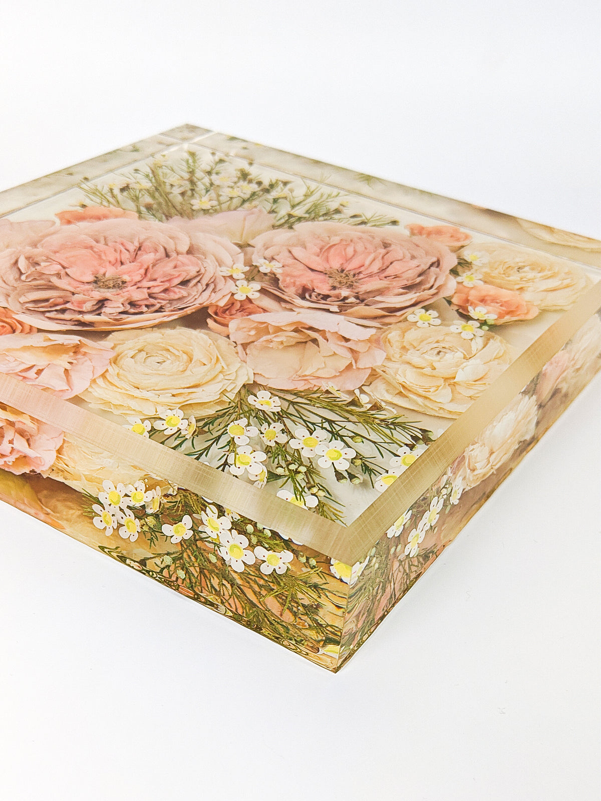 A square decorative resin block with preserved florals featuring pink and cream roses, green foliage, and small white flowers, shown on a plain white background.