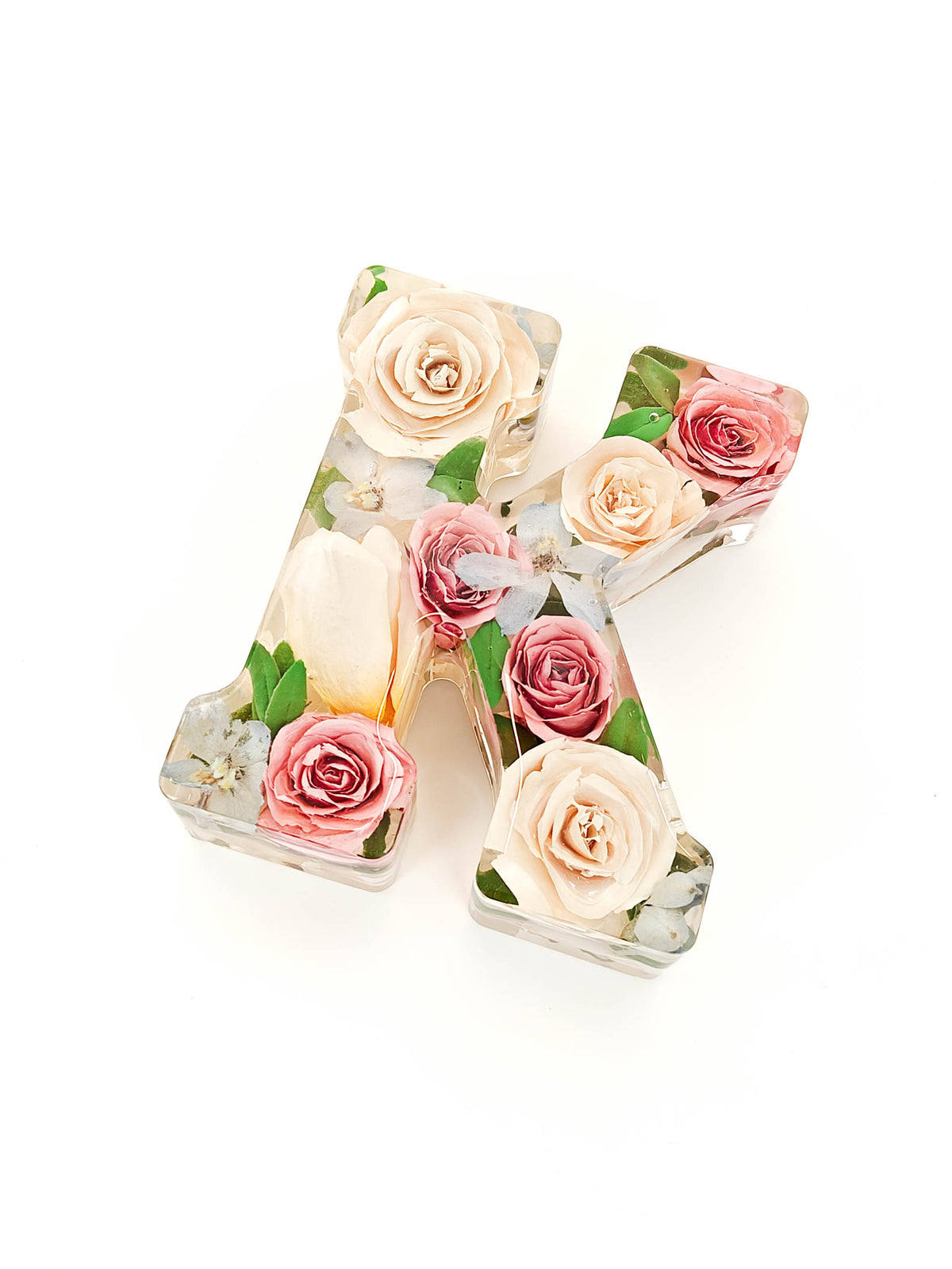 A decorative resin letter 'A' filled with preserved flowers, including pink roses, cream tulips, and green leaves, set against a plain white background.