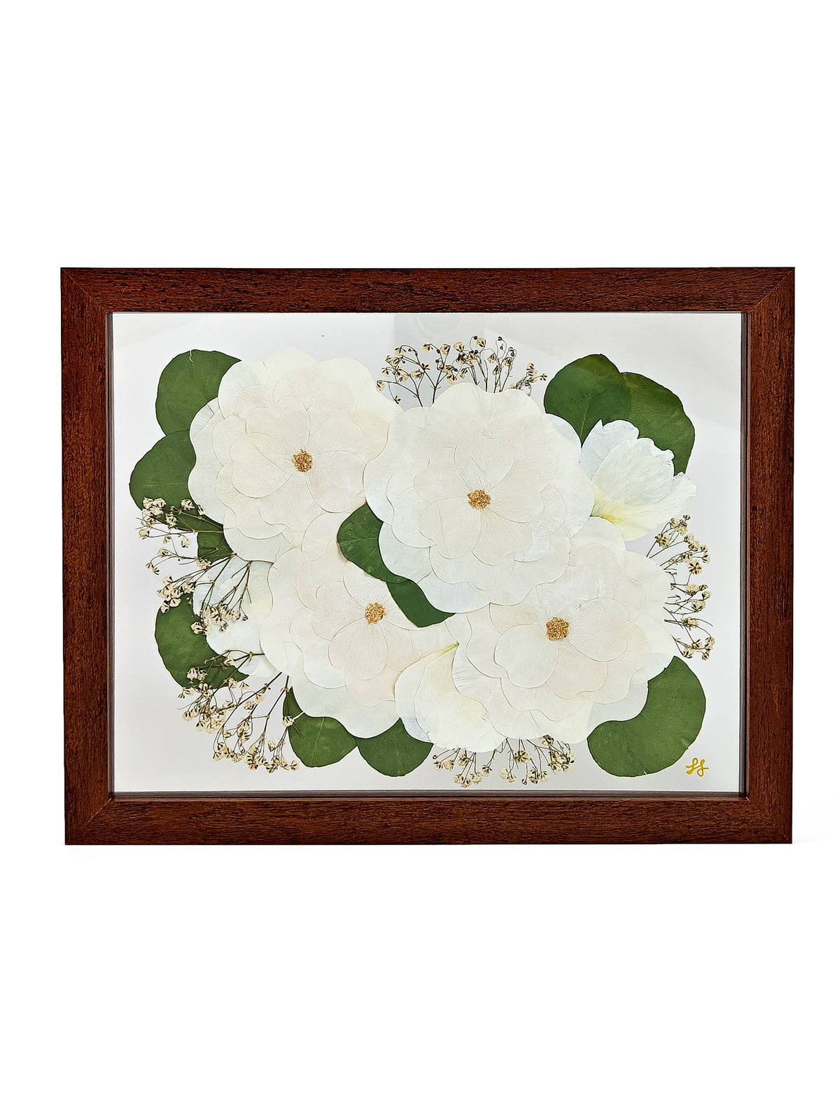 Framed botanical art print featuring pressed white flowers and green leaves with gold foil accents, set in a dark brown wooden frame against a white background.